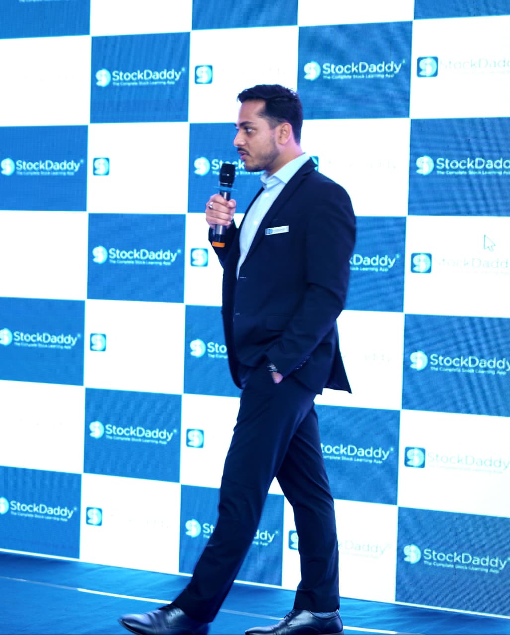 Alok speaking on stage at an event